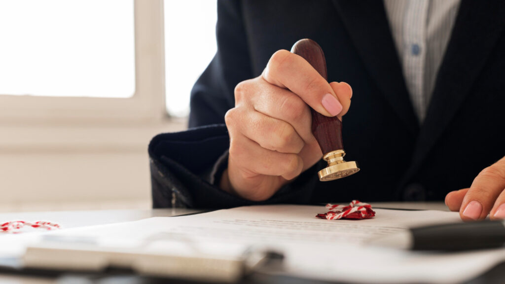 professional in a suit stamping an official legal document with a wax seal, representing the patent publication and opposition process under the Indian Patents Act.