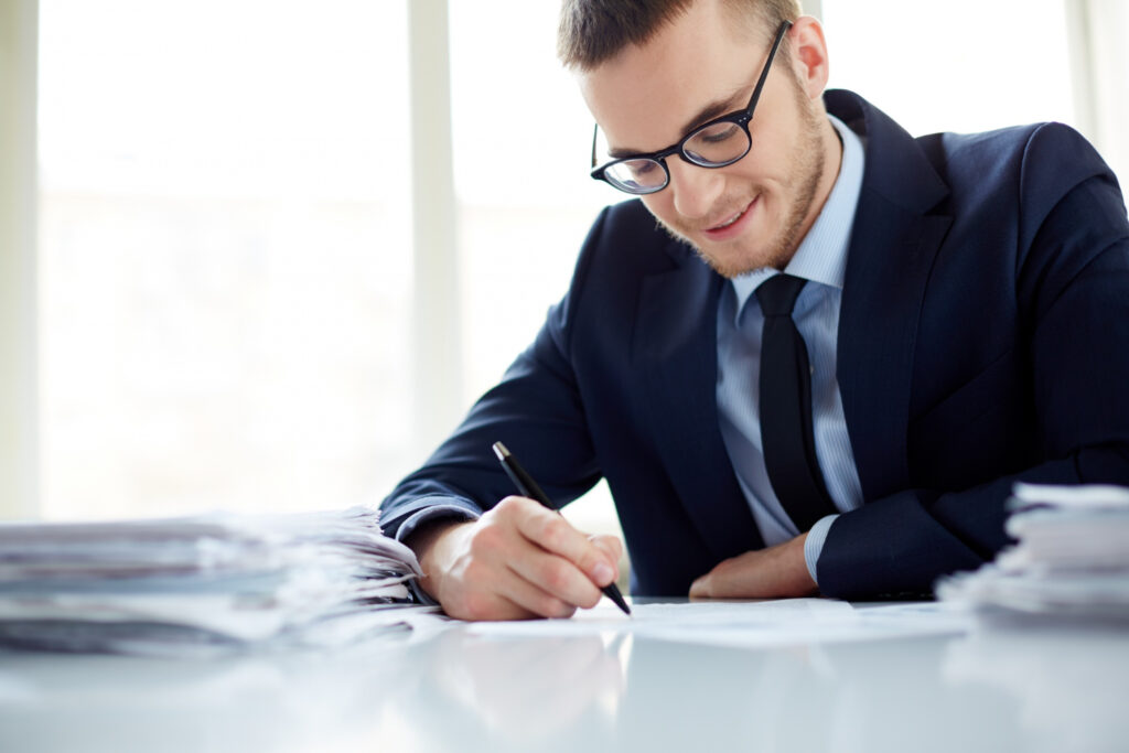Text explaining the process of trademark amendment via the CGPDTM website alongside an image of a professional signing paperwork.