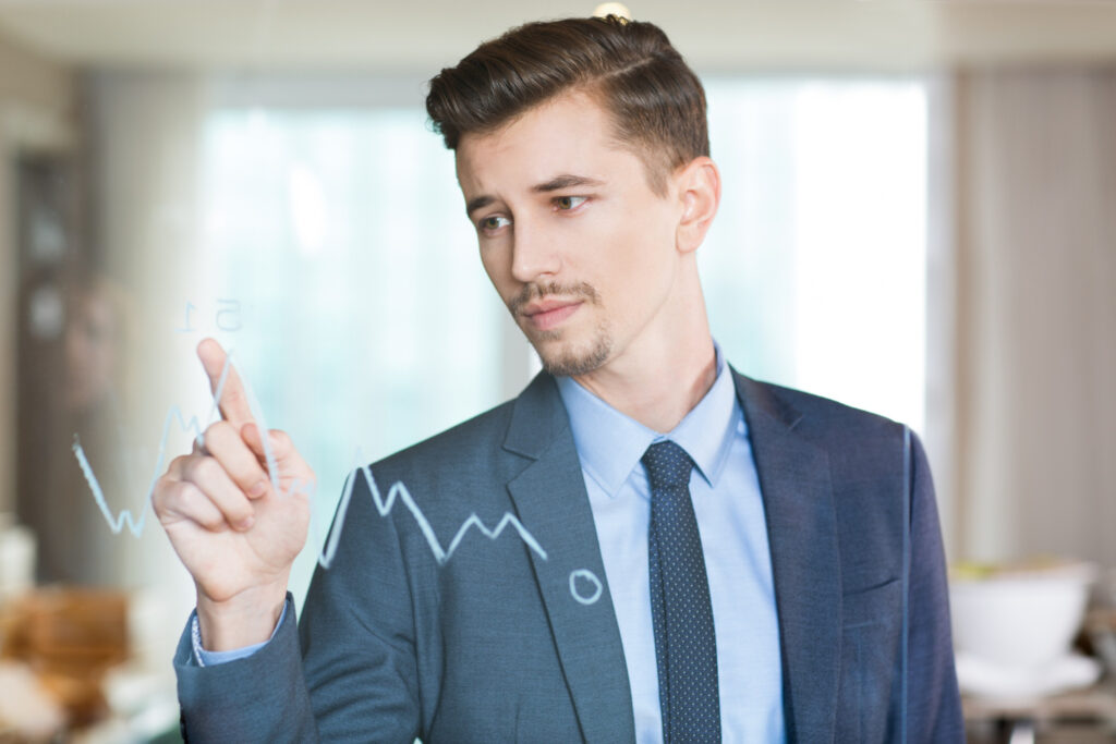 Professional businessman pointing at growth trends, representing company reliability and trademark protection benefits.