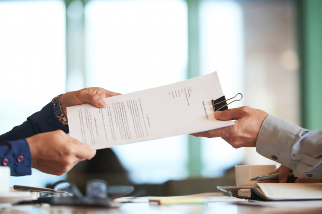 List of required paperwork for trademark restoration filing in India alongside an image of hands exchanging legal documents.