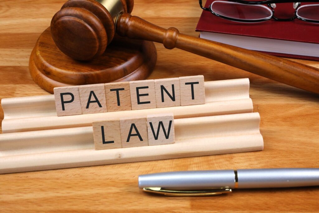 An image explaining Patent Law in India alongside a legal gavel, a pen, and wooden blocks spelling "PATENT LAW