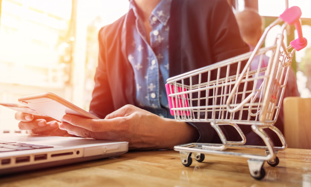 A person managing an e-commerce store on a laptop, symbolizing the risks of selling a new invention or product without a patent.